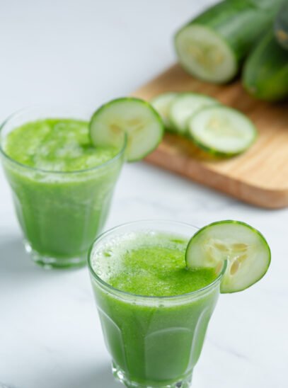 Glass of fresh cucumber juice on marble background