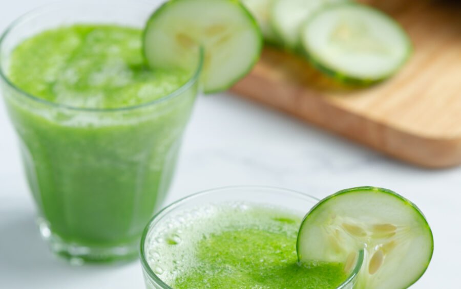 Glass of fresh cucumber juice on marble background